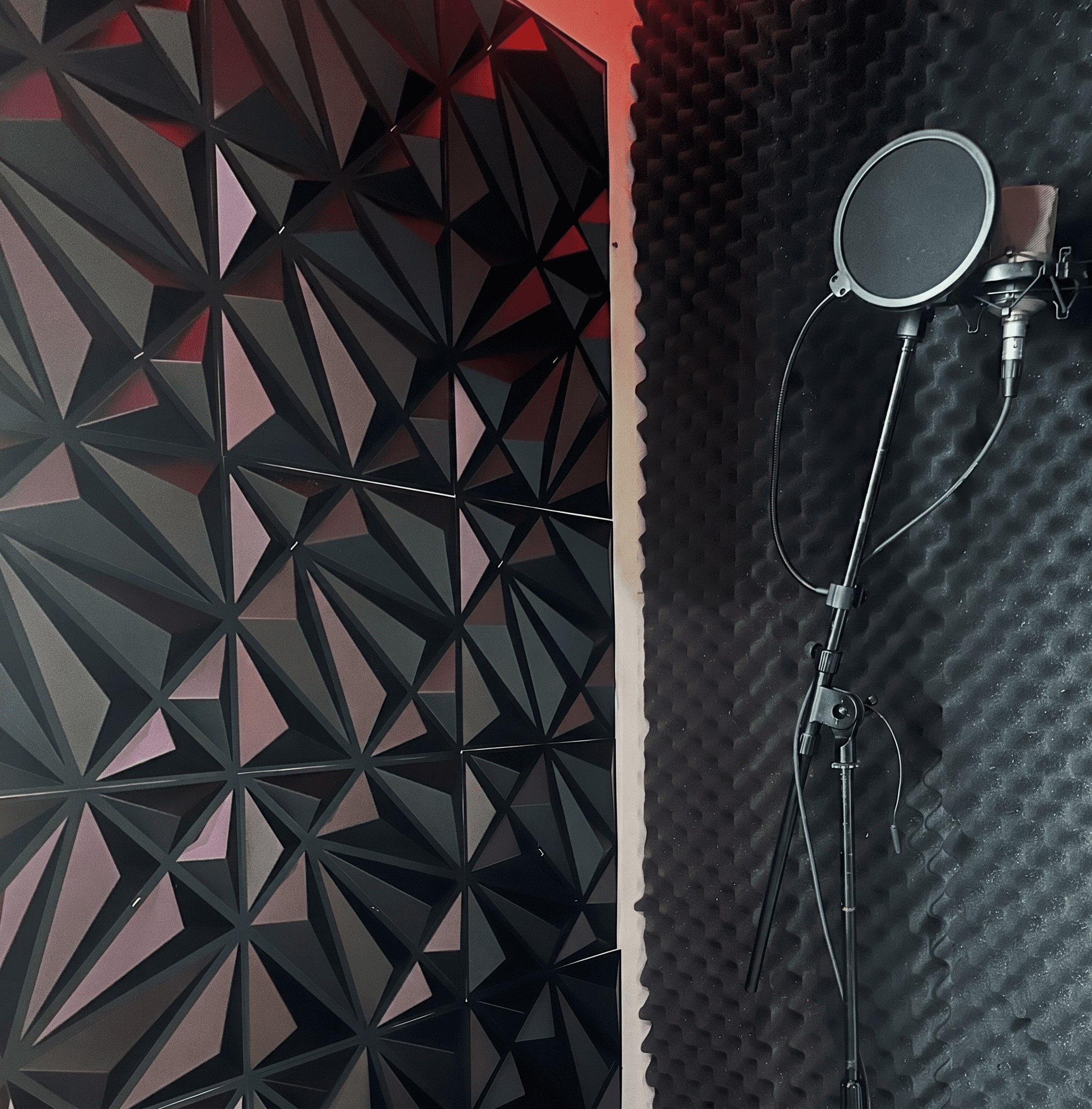 Vocal booth with geometric acoustic panels and condenser mic